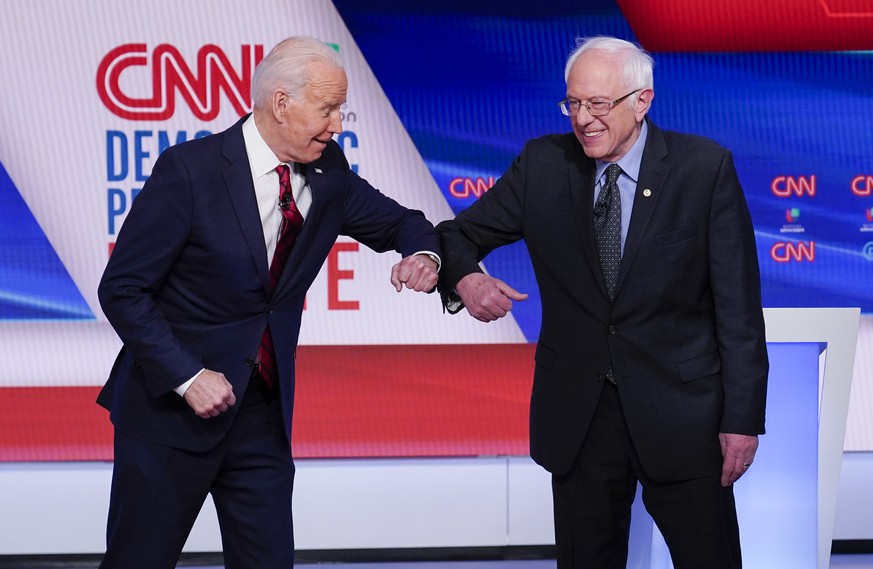 Former Vice President Joe Biden, left, and Sen. Bernie Sanders, I-Vt., right, greet one another before they participate in a Democratic presidential primary debate at CNN Studios in Washington, Sunday ...