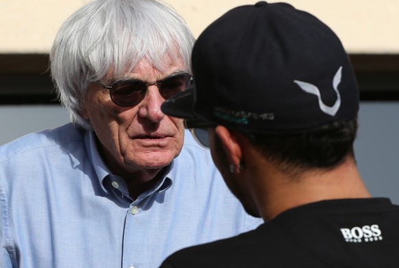 Bernie Ecclestone, President and CEO of Formula One Management, left, talks to Mercedes driver Lewis Hamilton of Britain ahead the Bahrain Formula One Grand Prix at the Formula One Bahrain Internation ...