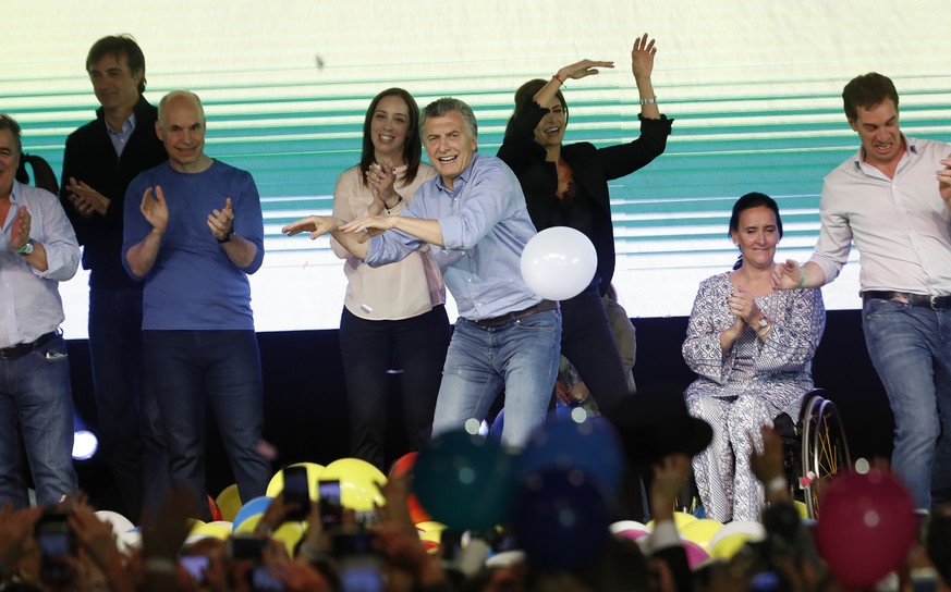 epa06283451 Argentinian President Mauricio Macri (C) dances as he celebrates next to the Governor of Buenos Aires Maria Eugenia Vidal (C-L) at the Cambiemos headquarters, in Buenos Aires, Argentina, 2 ...