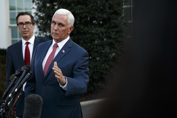 Vice President Mike Pence, with Treasury Secretary Steven Mnuchin, responds to a question outside the West Wing of the White House, Monday, Oct. 14, 2019, in Washington. The U.S. is calling for an imm ...