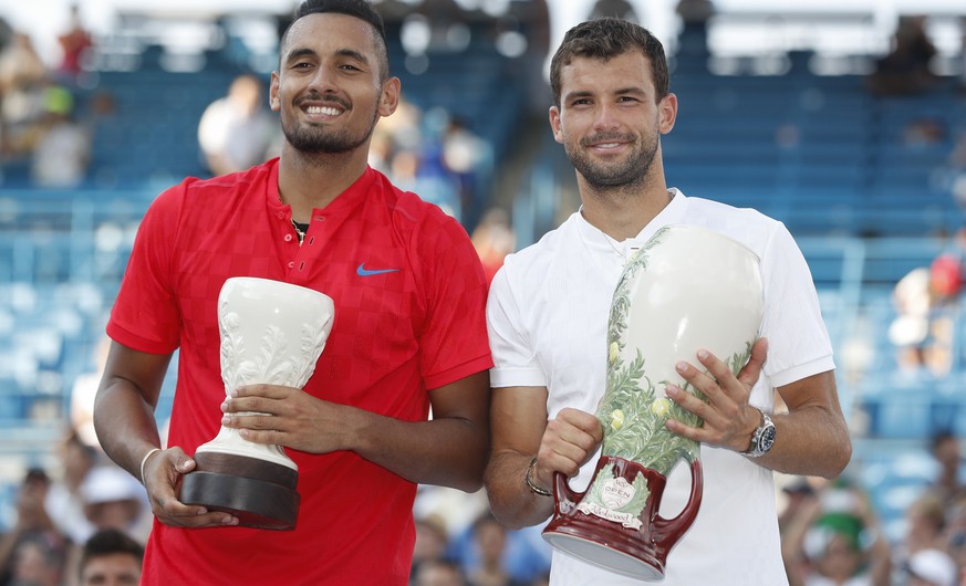 Grigor Dimitrov, of Bulgaria, right, holds the Rookwood Cup after defeating runner-up Nick Kyrgios, of Australia, left, in the men&#039;s singles final at the Western &amp; Southern Open, Sunday, Aug. ...