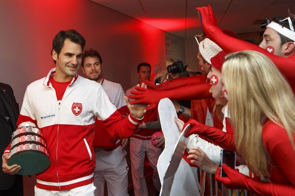 Federer klatscht mit der Mini-Trophäe in der Hand mit den Fans ab.