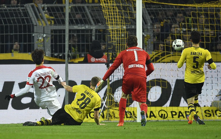 Augsburg&#039;s Dong-Won Ji, left, scores the opening goal during the German Bundesliga soccer match between Borussia Dortmund and FC Augsburg in Dortmund, Germany, Tuesday, Dec. 20, 2016. (AP Photo/M ...