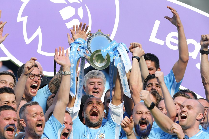 epa06715341 Manchester City&#039;s manager Pep Guardiola (C) lifts the Premier League trophy with staff following the English Premier League soccer match between Manchester City and Huddersfield Town  ...
