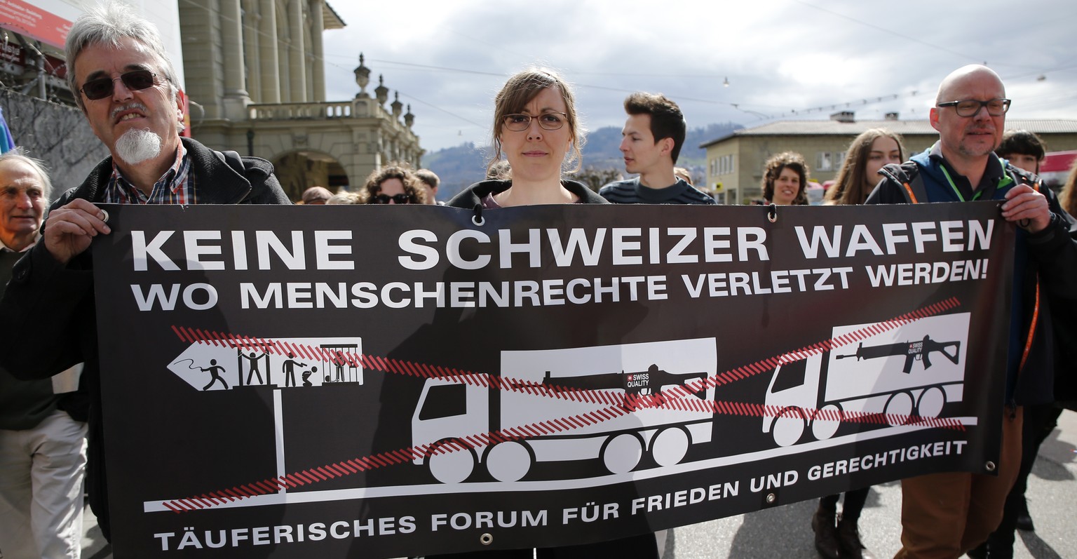 Friedensaktivisten halten ein Plakat mit der Aufschrift &quot;Keine Schweizer Waffen wo Menschenrechte verletzt werden&quot; beim traditionellen Ostermarsch durch die Stadt Bern, am Ostermontag, 28. M ...