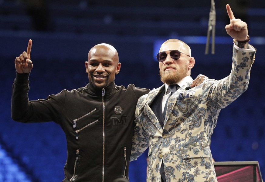 Floyd Mayweather Jr., left, and Conor McGregor pose during a news conference after a super welterweight boxing match Sunday, Aug. 27, 2017, in Las Vegas. (AP Photo/Isaac Brekken)