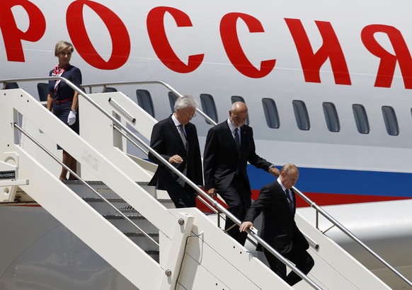 Russian President Vladimir Putin, right, is followed by Italian Head of the Diplomatic Protocol Inigo Lambertini, second from right, as he steps off the plane as he arrives at Rome&#039;s internationa ...