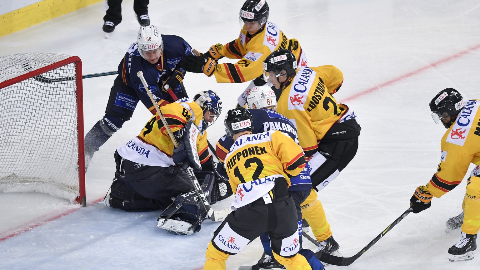 Kalevan Pallo&#039;s goalkeeper Daniel Manzato, center, fights for the puck during the game between HK Metallurg Magnitogorsk and KalPa Kuopio Hockey Oy at the 92th Spengler Cup ice hockey tournament  ...