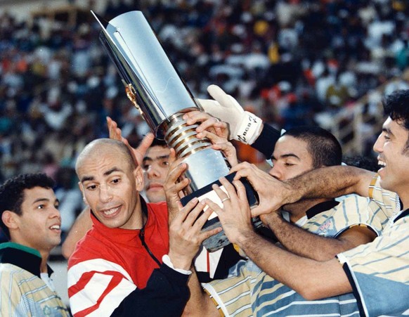 The Egyptian national soccer team helps captain Hassan Hossam, left, hold up the African Nations Championship cup after deafeating defending champions South Africa 2-0 in Ouagadougou, Burkina Faso, Sa ...