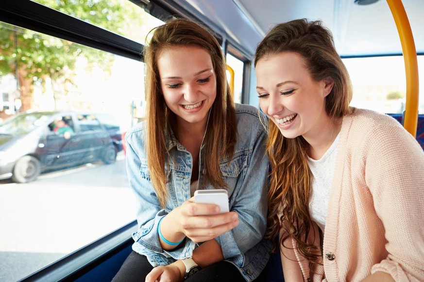 Zwei junge Frauen mit Smartphone im Bus (Symbolbild)