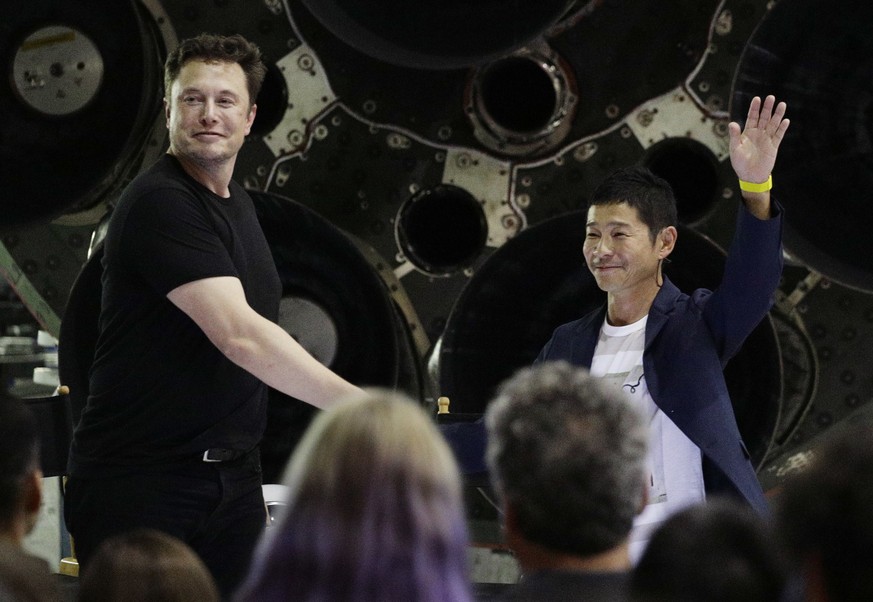 SpaceX founder and chief executive Elon Musk, left, shakes hands with Japanese billionaire Yusaku Maezawa, right, after announcing him as the first private passenger on a trip around the moon, Monday, ...