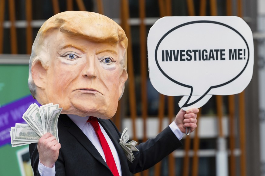 IMAGE DISTRIBUTED FOR AVAAZ - A member of the global citizens movement Avaaz wearing a mask of former US President Donald Trump holds a sign reading &quot;Investigate me&quot;, outside the Scottish Pa ...