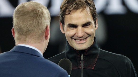Switzerland&#039;s Roger Federer smiles as he is interviewed by former champion Jim Courier after defeating Tomas Berdych of the Czech Republic in their quarterfinal at the Australian Open tennis cham ...