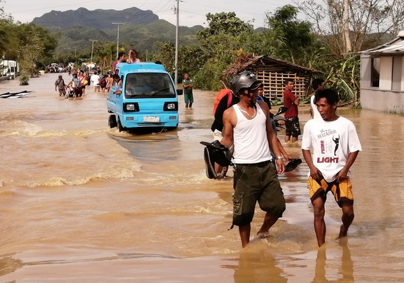 epa08089576 Motorists wade through water on a flooded road on Christmas day in the typhoon-hit city of Ormoc, Philippines, 25 December 2019. Typhoon Phanfone, (locally known as Ursula), made landfall  ...