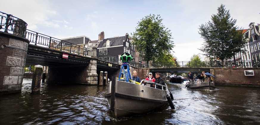 epa04360363 A boat carrying a 360-degree Google camera sails through the city canals of Amsterdam, The Netherlands, 19 August 2014. The camera, mounted on a small vessel, takes photos for the Google S ...