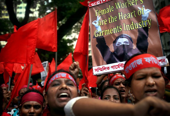 Protestors shout slogans calling for better working conditions for garment workers during a May Day rally on Wednesday, May 1, 2013 in Dhaka, Bangladesh. Thousands of garment factory workers paraded t ...