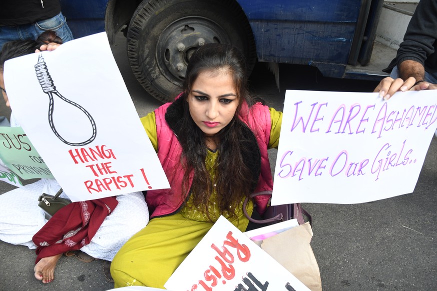 epa08034416 A woman holds placards as she protests after a 27-year-old was raped and killed, in New Delhi, India, 30 November 2019. According to media reports, an Indian veterinarian was gang-raped, m ...