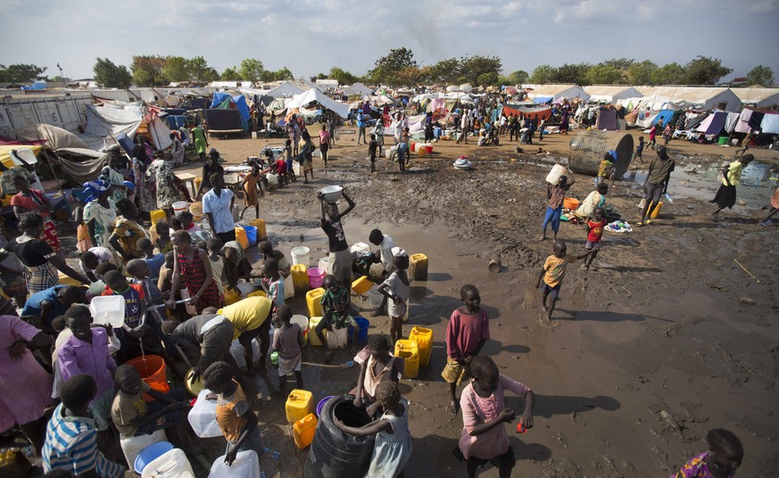 FILE - In this file photo of Sunday Dec. 29, 2013 file photo, displaced people gather around a water truck to fill containers at a United Nations compound which has become home to thousands of people  ...