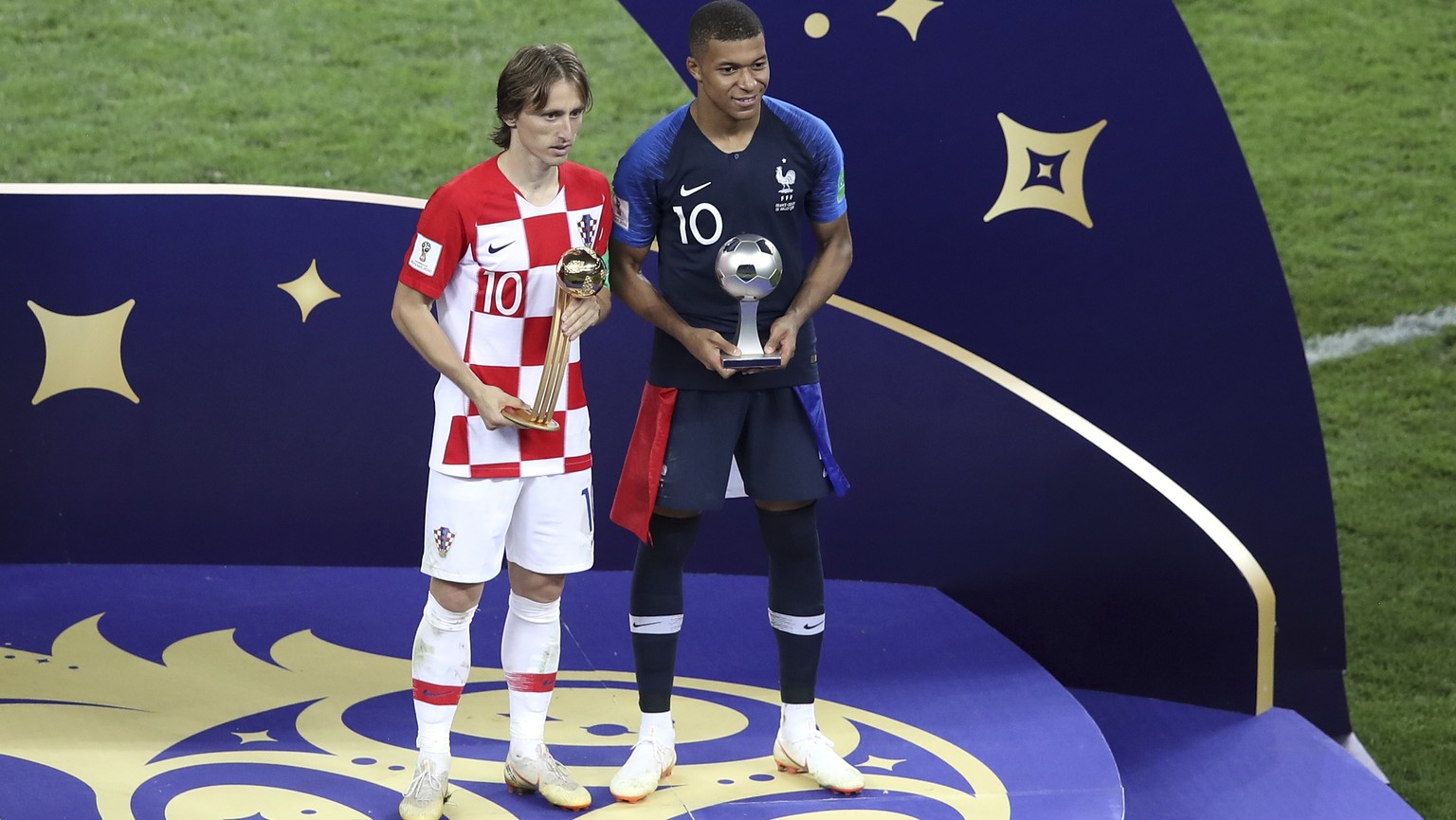 Croatia&#039;s Luka Modric and France&#039;s Kylian Mbappe, right, pose with their individual awards at the end of the final match between France and Croatia at the 2018 soccer World Cup in the Luzhni ...