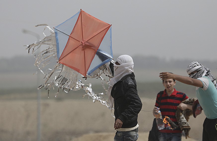 epaselect epa06682560 A kite with a Molotov cocktail is launched by Palestinians protesters during clashes near the Israel border in the east of Gaza City, 20 April 2018. Two Palestinian protesters ha ...