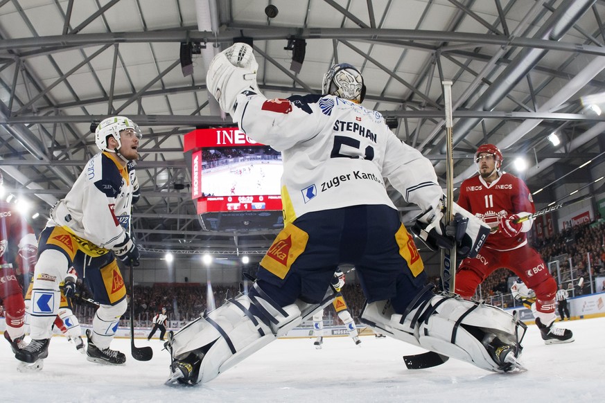 Zug&#039;s defender Thomas Thiry, of France, left, Zug&#039;s goaltender Tobias Stephan, center, and Lausanne&#039;s forward Yannick Herren, right, look on the puck, during the third leg of the playof ...