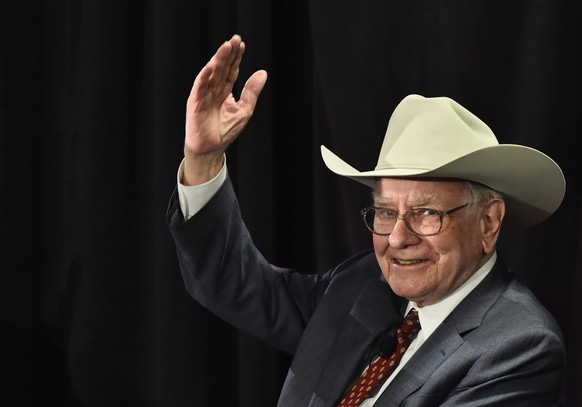 epa04696385 Nebraska Furniture Mart and Berkshire Hathaway, CEO Warren Buffett waves to the crowd after playing a ukulele while wearing a cowboy hat after answering questions for a crowd inside his ne ...