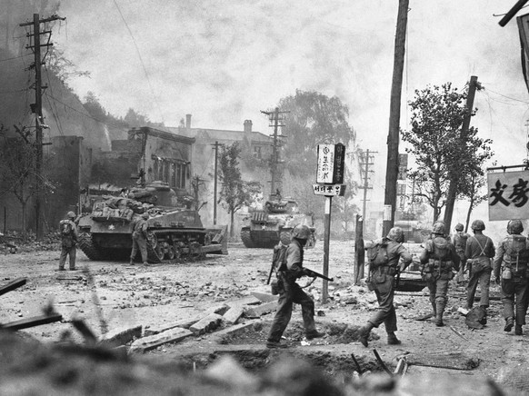Smoke rises over debris-littered streets as tanks lead U.N. forces in the recapture of Seoul, Korea, Sept. 28, 1950. (AP Photo/Max Desfor)