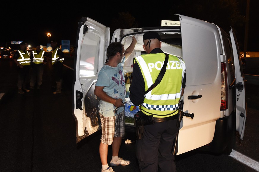 Ein österreichischer Grenzpolizist kontrolliert einen Van.