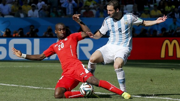 Argentina&#039;s Gonzalo Higuain is challenged by Switzerland&#039;s Johan Djourou during the World Cup round of 16 soccer match between Argentina and Switzerland at the Itaquerao Stadium in Sao Paulo ...