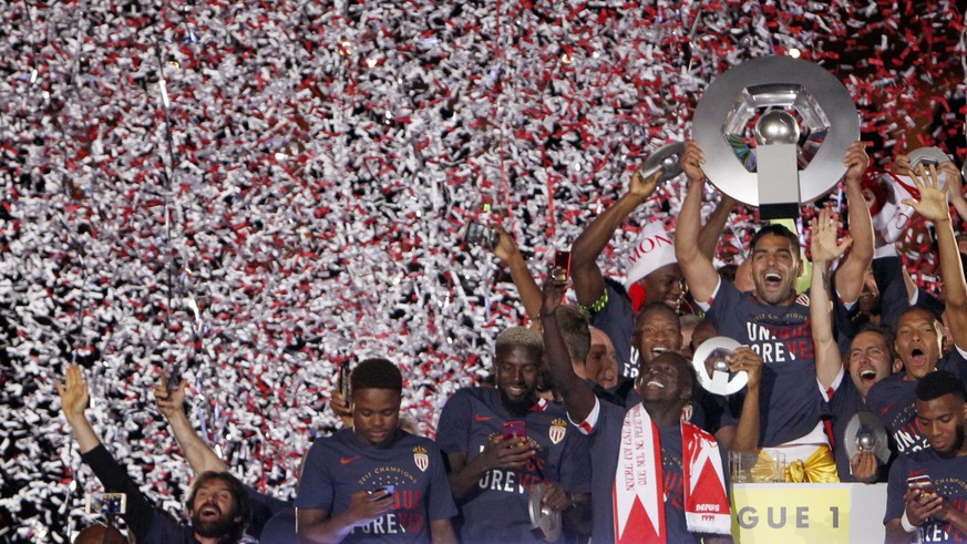 FILE - In this May 17, 2017 file photo, Monaco players hold the trophy as they celebrate their French League One title after beating Saint Etienne during the League One soccer match Monaco against Sai ...