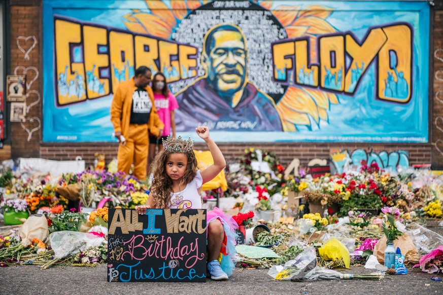 MINNEAPOLIS, MN - JUNE 9: A girl holds her fist in the air while visiting the memorial for George Floyd on June 9, 2020 in Minneapolis, Minnesota. Residents of the community, and people around the wor ...