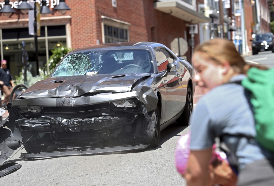A vehicle reverses after driving into a group of protesters demonstrating against a white nationalist rally in Charlottesville, Va., Saturday, Aug. 12, 2017. The nationalists were holding the rally to ...