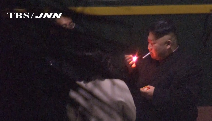 In this image made from Japan’s TBS TV video on early Tuesday, Feb. 26, 2019, North Korean leader Kim Jong Un, a habitual smoker, takes a pre-dawn smoke break at the train station in Nanning, China, h ...