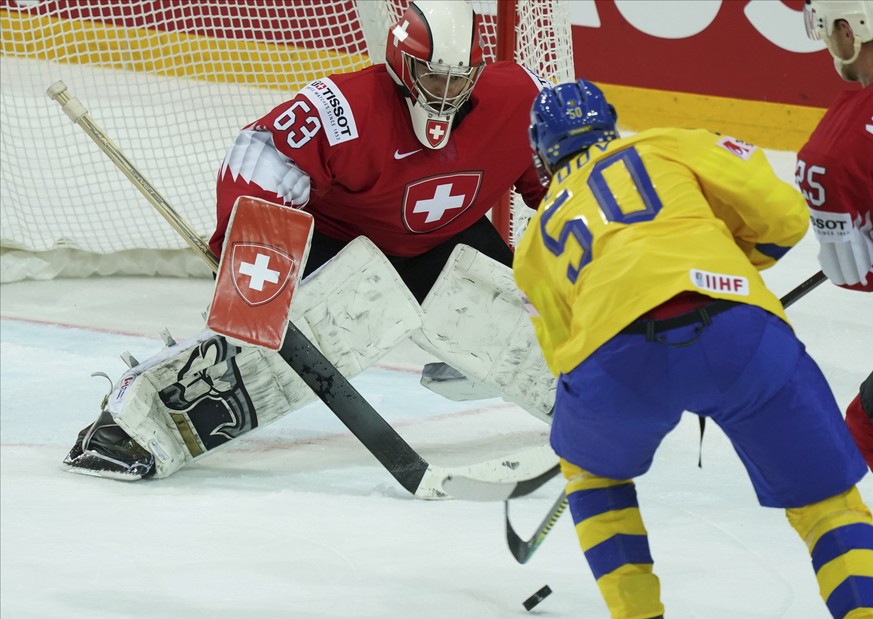 Switzerland&#039;s Leonardo Genoni left, fight for a puck with Sweden&#039;s Viktor Loov during the Ice Hockey World Championship group A match between Switzerland and Sweden at the Olympic Sports Cen ...