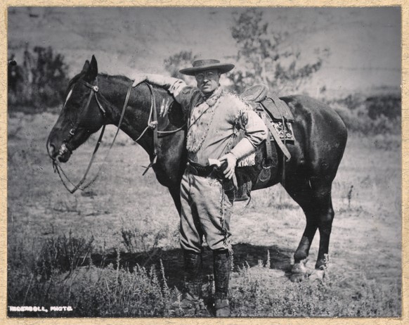 This 1884 photo provided by the Theodore Roosevelt Center shows Theodore Roosevelt standing with a saddled horse in the Badlands of Dakota Territory. Roosevelt originally came to what is now North Dak ...