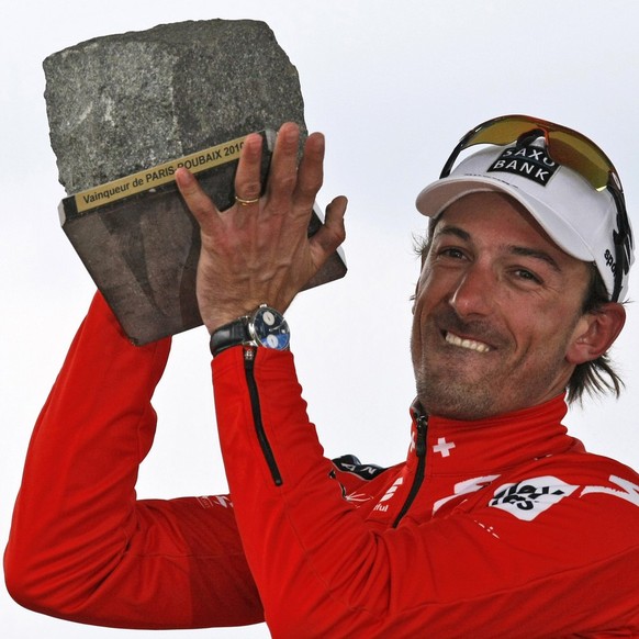 Switzerland&#039;s Fabian Cancellara of Team Saxo Bank holds the trophy on the podium after winning the 108th edition of the Paris-Roubaix cycling classic race, in Roubaix, northern France, Sunday, Ap ...