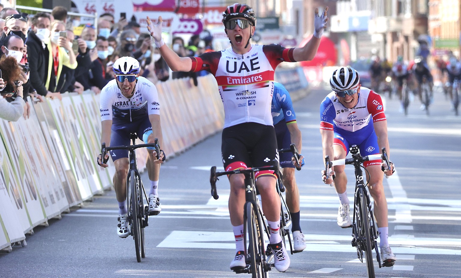 Slovenia&#039;s Tadej Pogacar, center, of the UAE team Emirates crosses the finish line to win the Belgian cycling classic and UCI World Tour cycling race Liege Bastogne Liege, in Liege, Belgium, Sund ...