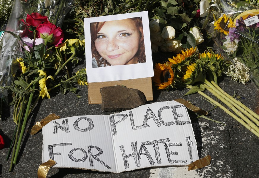 A makeshift memorial of flowers and a photo of victim, Heather Heyer, sits in Charlottesville, Va., Sunday, Aug. 13, 2017. Heyer died when a car rammed into a group of people who were protesting the p ...