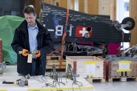 epa07191281 Michael Flueckiger, chief investigator of the aviation sector of the Swiss Transportation Safety Investigation Board STSB, examines parts of the wreckage of the Junkers JU-52, HB-HOT, airc ...