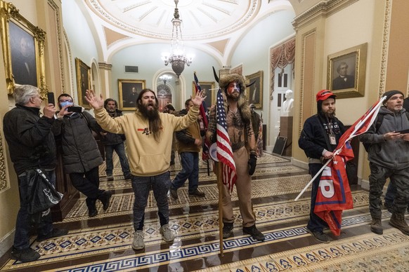FILE - In this Jan. 6, 2021, file photo, supporters of President Donald Trump are confronted by U.S. Capitol Police officers outside the Senate Chamber inside the Capitol in Washington. Online support ...