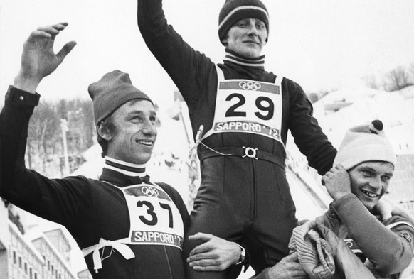 Bei der Siegerehrung im 90m Skispringen der olympischen Winterspiele in Sapporo im Februar 1972 wird der Goldmedaillengewinner Wojciech Fortuna, Polen, Mitte, von Walter Steiner, Schweiz, links, Silbe ...