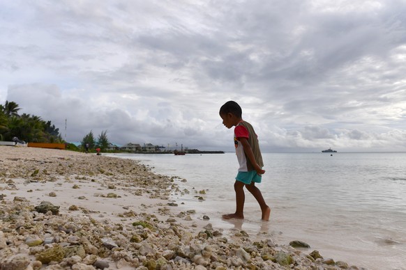 epa07770649 A child walks along the shore of the lagoon in Funafuti, Tuvalu, 13 August 2019. The 50th Pacific Islands Forum and Related Meetings, fostering cooperation between governments comprising 1 ...