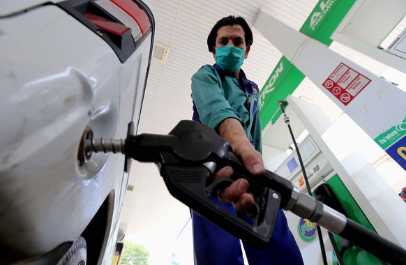 epa08457924 A gas station attendant fills a car in Peshawar, Pakistan, 01 June 2020. Government announced that it had slashed petrol prices for May owing to sharp decline in crude oil prices in the in ...