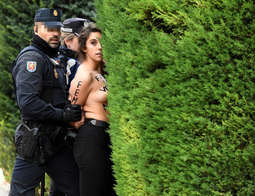 epa07175145 Two policemen arrest a FEMEN activist after several FEMEN activists disrupted a rally held to mark the anniversary of the death of Spanish dictator Francisco Franco, in Oriente Square, dow ...