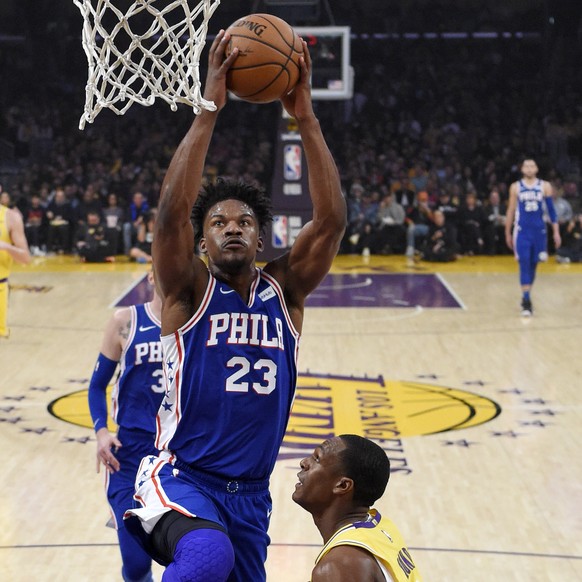Philadelphia 76ers guard Jimmy Butler, left, goes up for a dunk as Los Angeles Lakers guard Rajon Rondo defends during the first half of an NBA basketball game Tuesday, Jan. 29, 2019, in Los Angeles.  ...