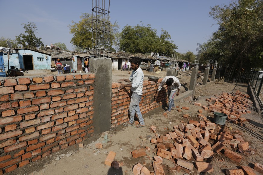 Indian workers construct a wall in front of a slum ahead of U.S. President Donald Trump&#039;s visit, in Ahmadabad, India, Monday, Feb. 17, 2020. Trump is scheduled to visit the city during his Feb. 2 ...