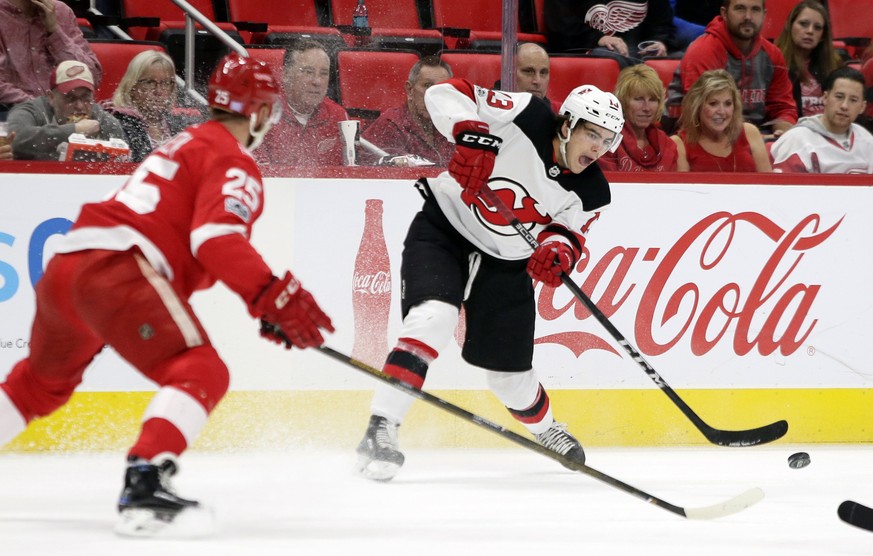 New Jersey Devils center Nico Hischier (13), of Switzerland, passes the puck against Detroit Red Wings defenseman Mike Green (25) during the first period of an NHL hockey game Saturday, Nov. 25, 2017, ...
