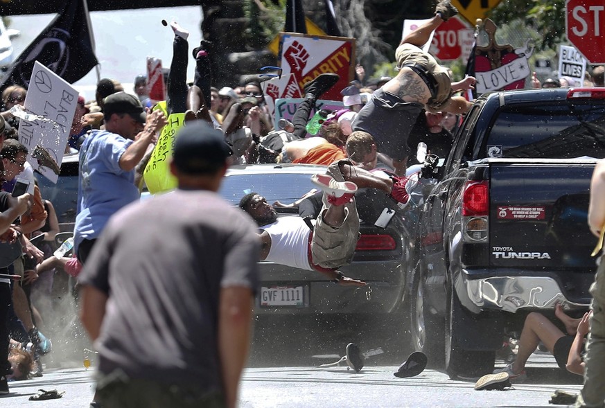 FILE - In this Aug. 12, 2017, file photo, people fly into the air as a vehicle is driven into a group of protesters demonstrating against a white nationalist rally in Charlottesville, Va. James Alex F ...
