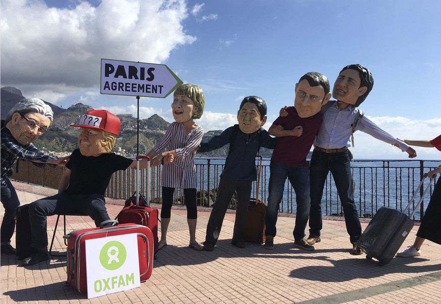 Oxfam activists wearing masks of the leaders of the G7 summit; from left, Italian Premier Paolo Gentiloni, US President Donald Trump, German Chancellor Angela Merkel, Japanese Prime Minister Shinzo Ab ...