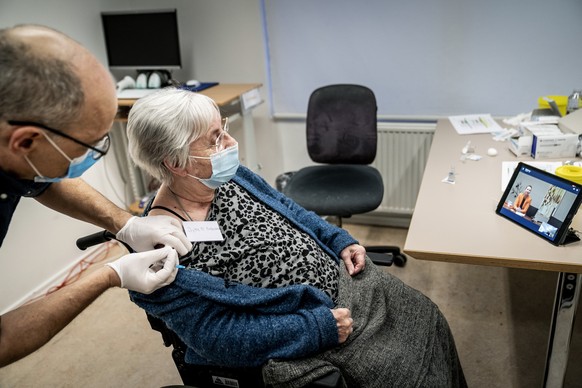 Jytte Margrete Frederiksen is vaccinated by Doctor Tomas Johanson in Ishoej, Denmark, Sunday, Dec. 27, 2020. Danish Prime Minister Mette Frederiksen watched the vaccination via videolink from Marienbo ...
